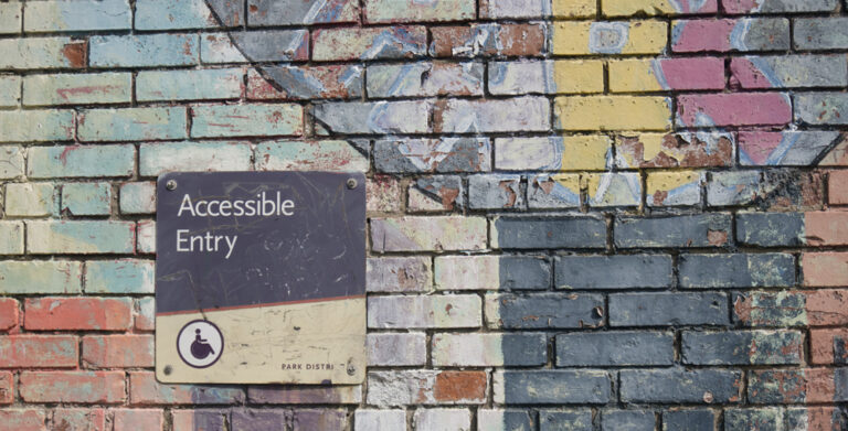 Accessible Design - Shows a graffiti wall with a sign for accessible entry.